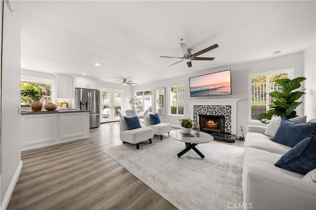 living area with a wealth of natural light, recessed lighting, a fireplace, and wood finished floors