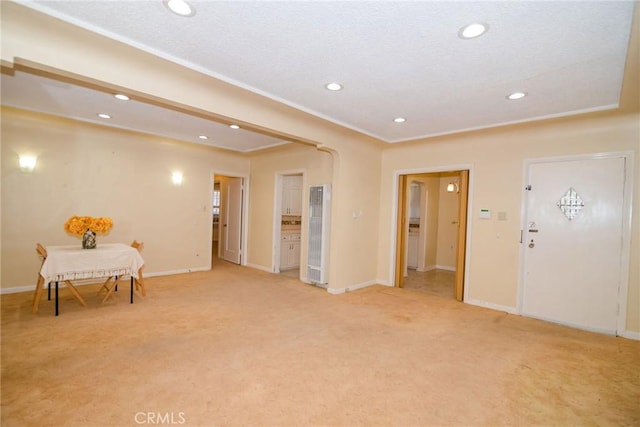 foyer entrance with recessed lighting, light colored carpet, crown molding, and baseboards