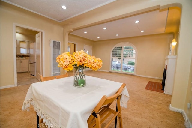 dining area with light carpet, recessed lighting, a fireplace, crown molding, and baseboards