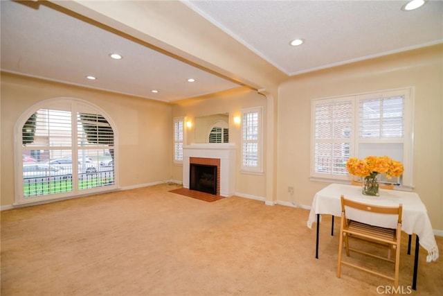 living area featuring baseboards, ornamental molding, light carpet, recessed lighting, and a fireplace