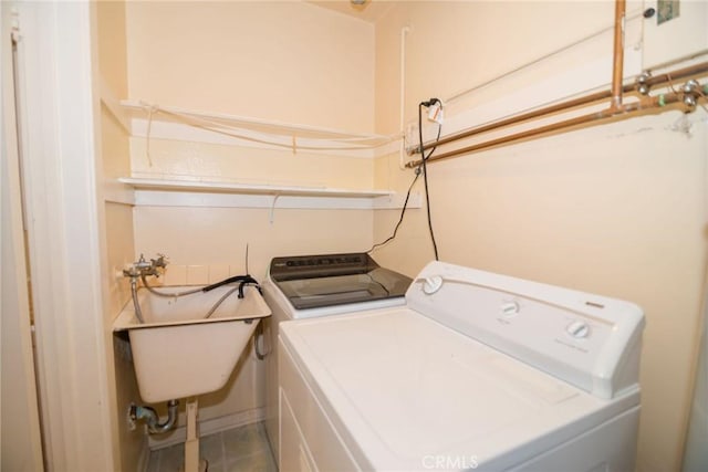 laundry area featuring a sink, laundry area, tile patterned flooring, and washer and clothes dryer