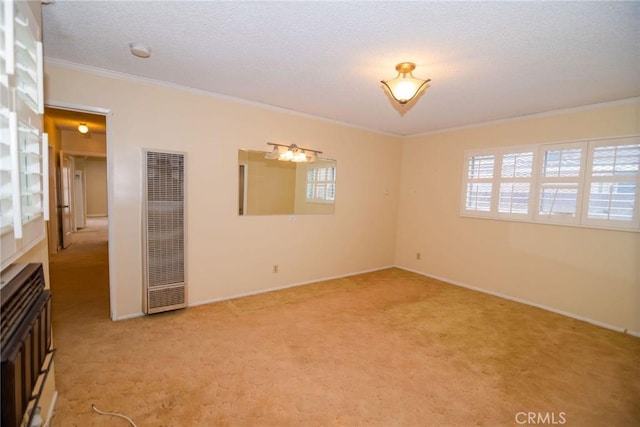 unfurnished room with baseboards, a heating unit, a textured ceiling, crown molding, and light carpet