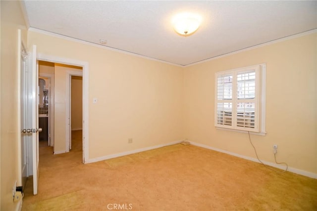 empty room with baseboards, light carpet, a textured ceiling, and crown molding