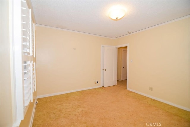 empty room with a textured ceiling, crown molding, baseboards, and light carpet