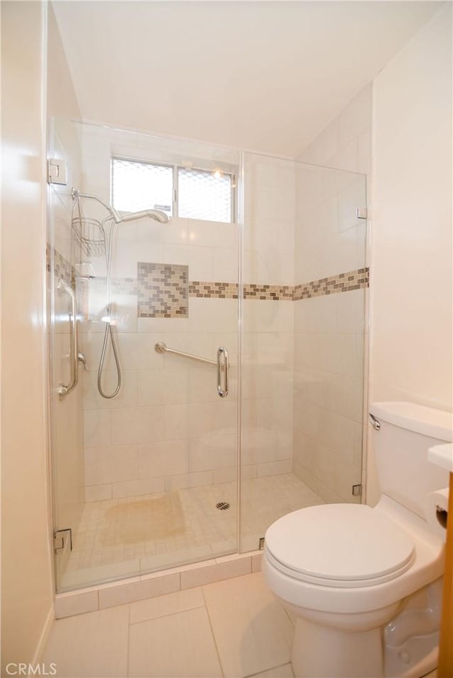 full bathroom with tile patterned flooring, a shower stall, and toilet