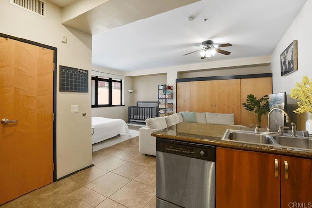 kitchen featuring a ceiling fan, visible vents, a sink, stainless steel dishwasher, and dark countertops