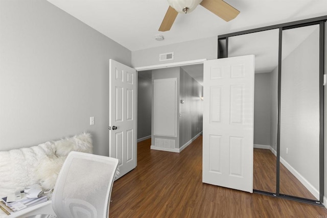 office space featuring a ceiling fan, wood finished floors, visible vents, and baseboards