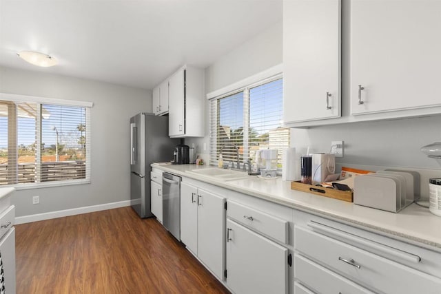 kitchen featuring a sink, appliances with stainless steel finishes, white cabinets, and light countertops