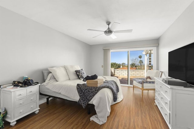 bedroom featuring wood finished floors, access to exterior, and a ceiling fan