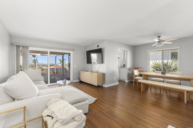 living room with a ceiling fan, visible vents, baseboards, and dark wood-style flooring