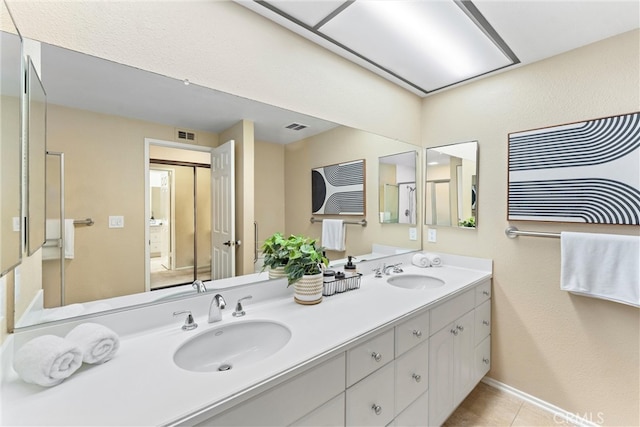 bathroom featuring double vanity, visible vents, tile patterned floors, and a sink