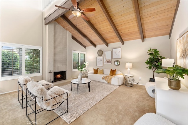 carpeted living area featuring beamed ceiling, high vaulted ceiling, a fireplace, and a ceiling fan