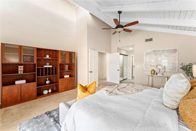 bedroom featuring vaulted ceiling with beams, light colored carpet, visible vents, and ceiling fan