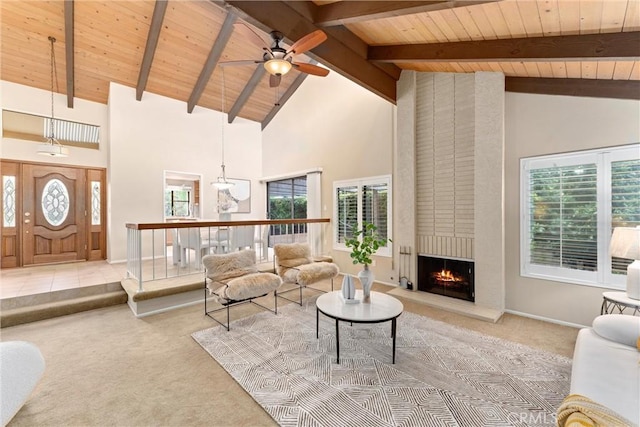 carpeted living area with a healthy amount of sunlight, a fireplace, wood ceiling, and a ceiling fan