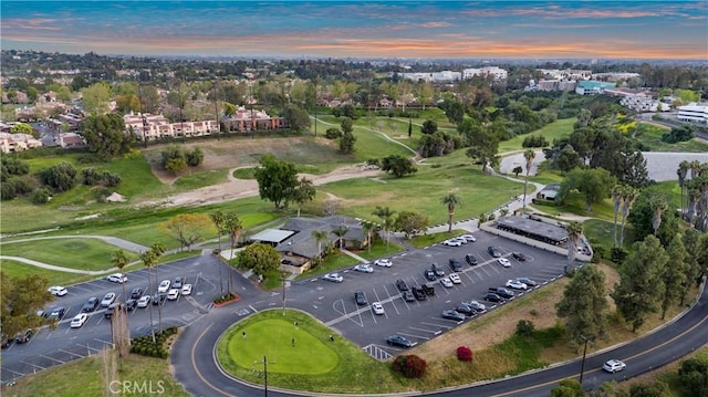 aerial view at dusk featuring golf course view