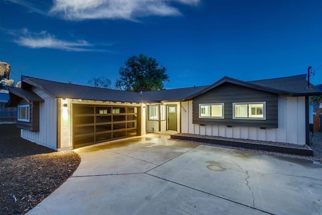 view of front facade with an attached garage, board and batten siding, and driveway