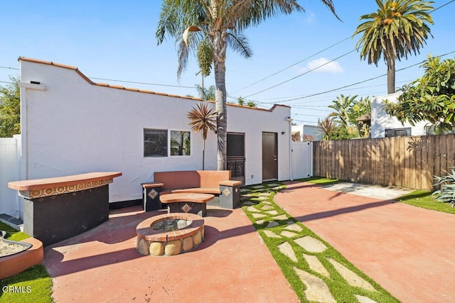 view of patio / terrace with a fire pit and fence