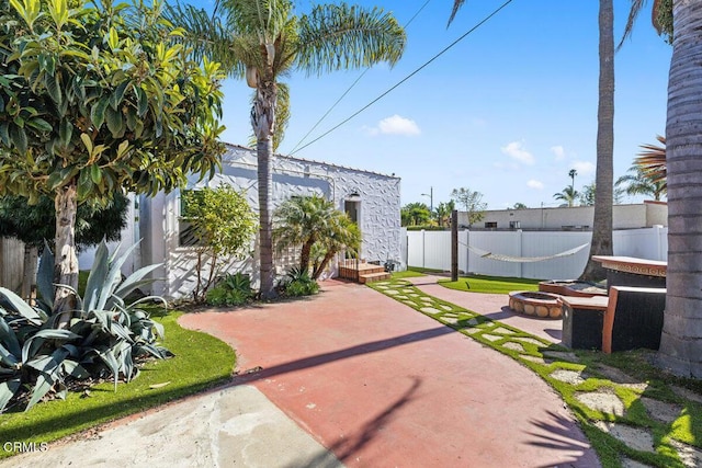 view of yard featuring a patio area, a fire pit, and fence