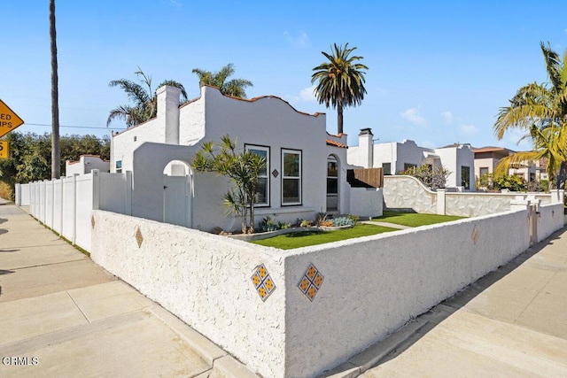 view of front of property with a residential view, stucco siding, and fence private yard