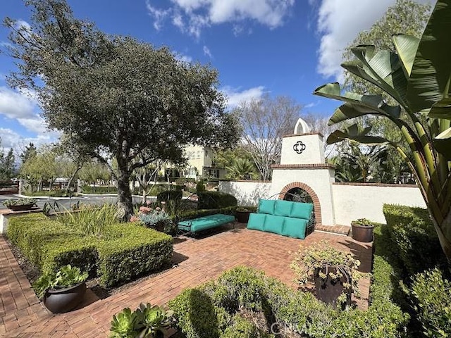 exterior space with an outdoor brick fireplace and a patio