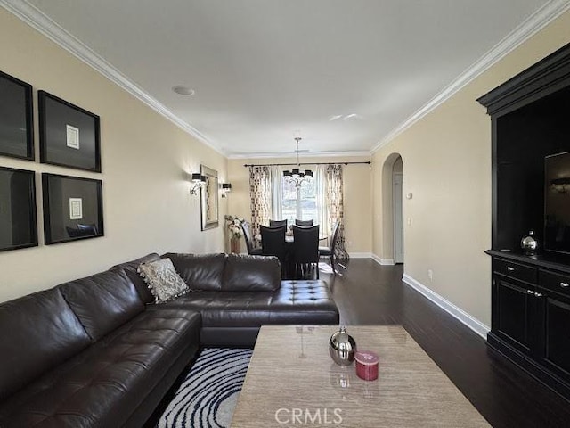 living room with crown molding, arched walkways, dark wood-type flooring, and a chandelier