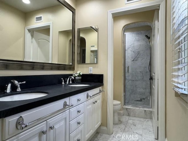 bathroom featuring a stall shower, toilet, marble finish floor, and a sink