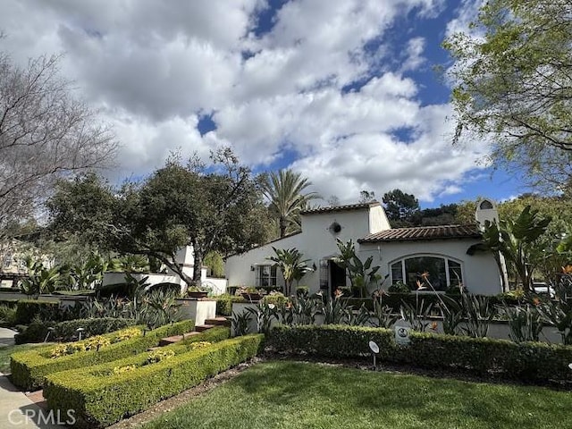 exterior space featuring stucco siding and a tile roof