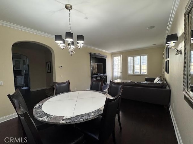 dining space featuring arched walkways, a notable chandelier, dark wood-style flooring, and ornamental molding