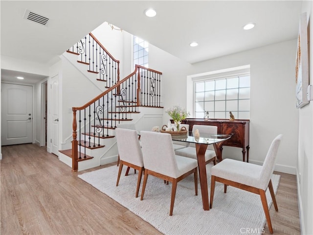 dining area with stairs, a healthy amount of sunlight, visible vents, and light wood finished floors