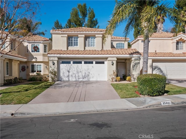 mediterranean / spanish-style house featuring stucco siding, driveway, a front yard, an attached garage, and a tiled roof