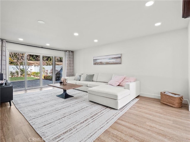 living room featuring wood finished floors, recessed lighting, and baseboards