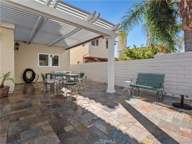 view of patio featuring outdoor dining space, a pergola, and fence