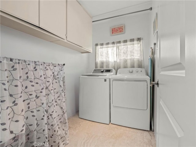 washroom featuring cabinet space and separate washer and dryer