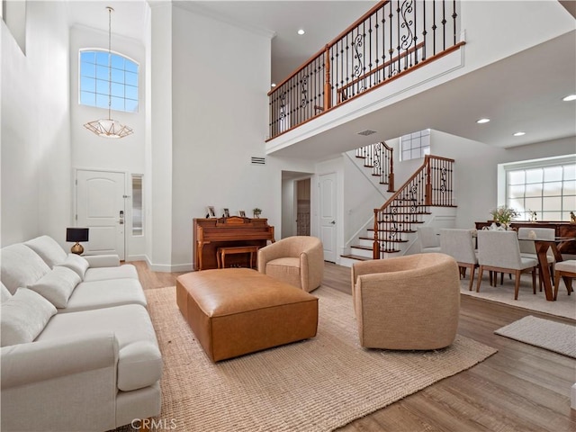 living area featuring visible vents, plenty of natural light, wood finished floors, and stairs