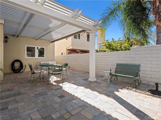 view of patio with outdoor dining space, a pergola, and fence