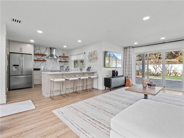 living room featuring recessed lighting, visible vents, and light wood-style floors