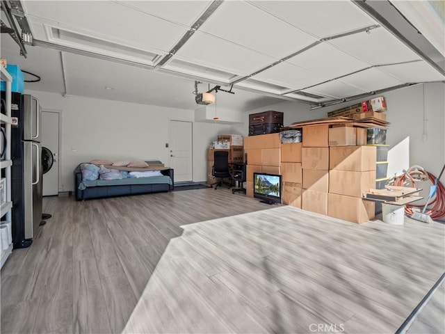 garage featuring a garage door opener and freestanding refrigerator