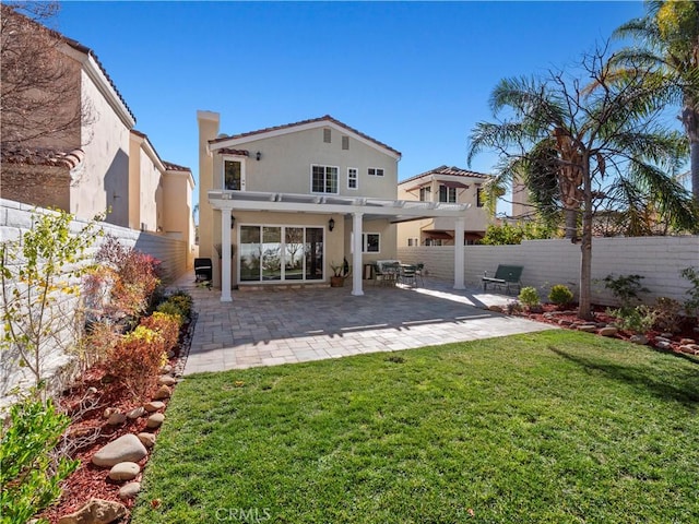 back of house with a patio, a yard, a fenced backyard, a pergola, and stucco siding