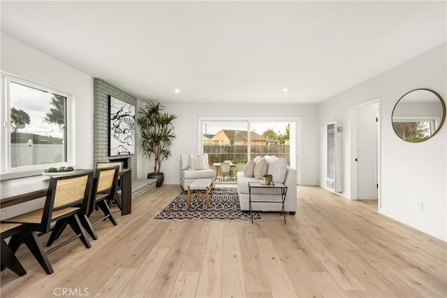 living area featuring recessed lighting, a fireplace, and light wood finished floors