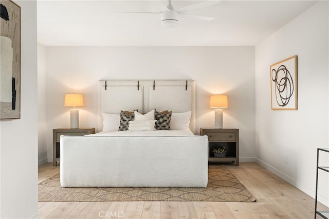 bedroom with baseboards, wood finished floors, and a ceiling fan