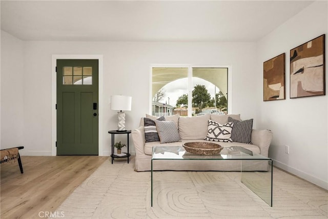 living area with baseboards and wood finished floors