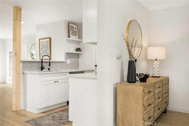 kitchen featuring backsplash, white cabinets, light countertops, and open shelves