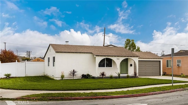 view of front of house featuring stucco siding, a front lawn, driveway, fence, and a garage