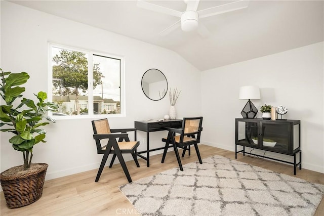 interior space featuring wood finished floors, a ceiling fan, baseboards, and vaulted ceiling