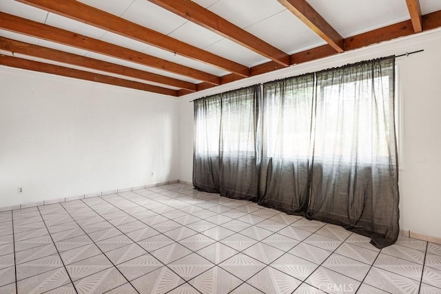 spare room with beam ceiling, light tile patterned floors, and baseboards