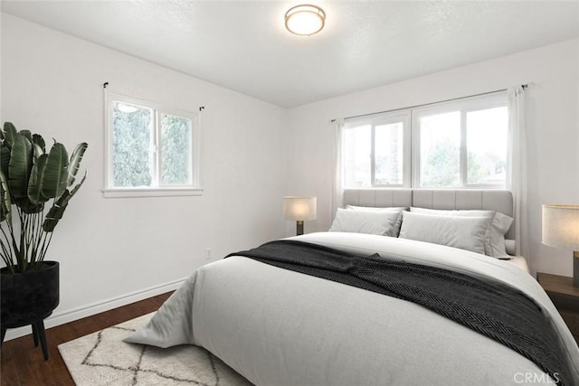 bedroom featuring wood finished floors and baseboards