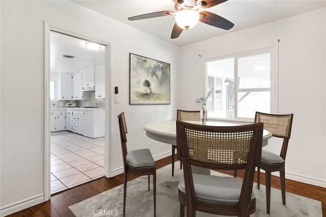 dining area featuring baseboards, wood finished floors, and a ceiling fan