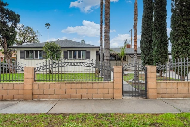 view of front of property with a fenced front yard, board and batten siding, and a gate