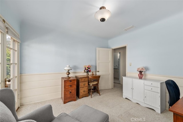 office with light carpet, visible vents, and wainscoting