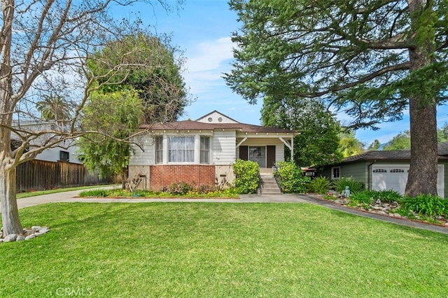 view of front of home featuring brick siding, a front lawn, and fence